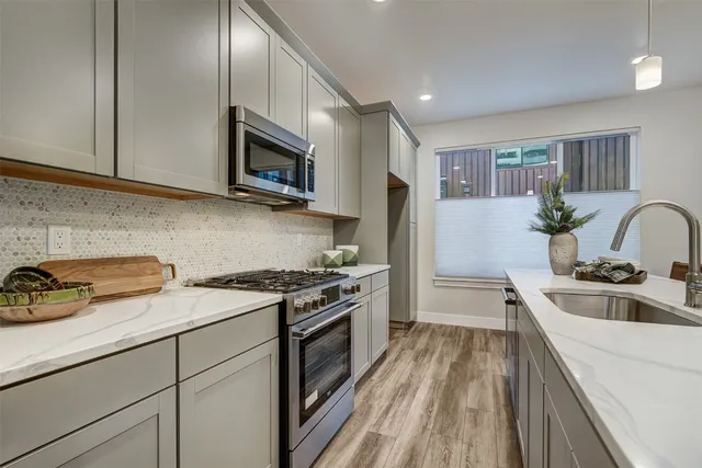 a kitchen with stainless steel appliances granite countertop a sink stove and refrigerator