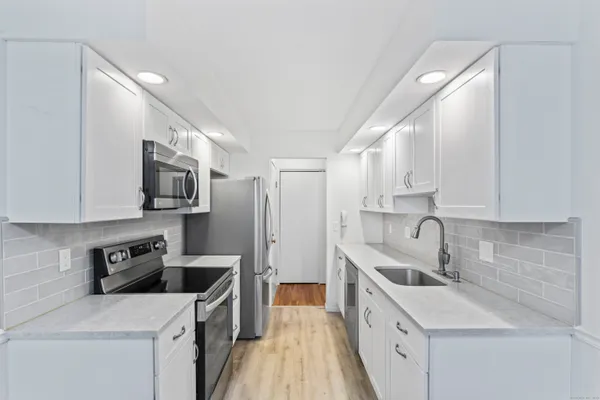 a kitchen with stainless steel appliances granite countertop a sink a stove and a refrigerator
