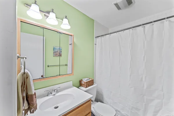 a bathroom with a sink vanity mirror and toilet
