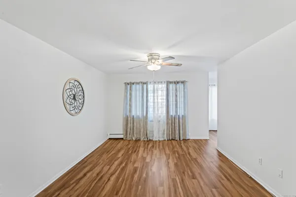 an empty room with a window and wooden floor
