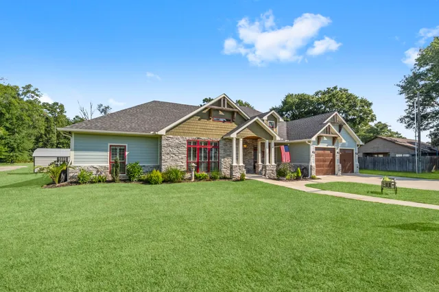 a front view of a house with a yard and trees