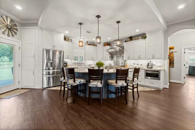 a kitchen with kitchen island granite countertop a sink stove and cabinets