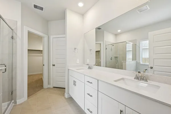 a spacious bathroom with a double vanity sink mirror and double