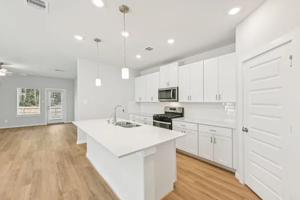 a kitchen with cabinets wooden floor and a sink