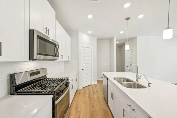 a kitchen that has a sink and a stove top oven