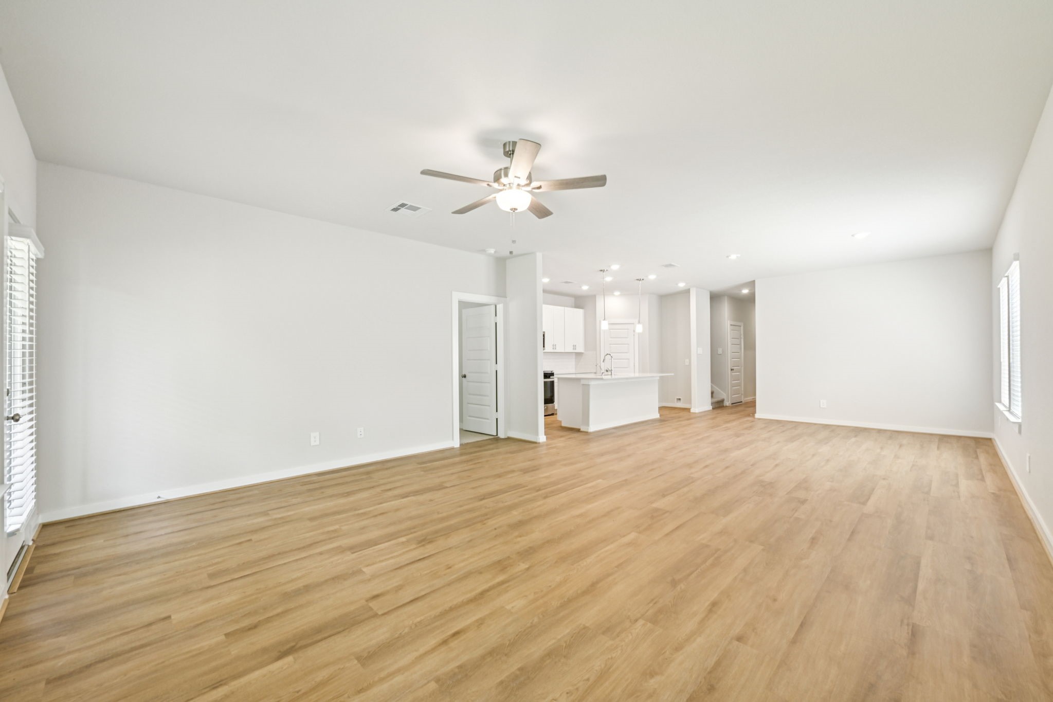 1653 Hopson Ranch Drive Conroe, TX 77301 - Photo 10 of 38 a view of an empty room with chandelier fan and wooden floor
