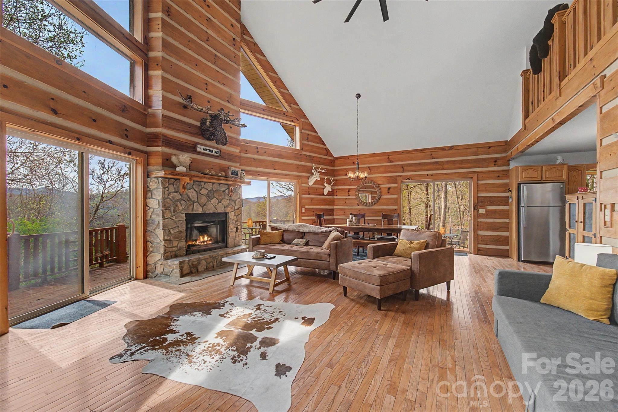 183 Ridge Place Bryson City, NC 28713 - Photo 6 of 44 a living room with furniture a fireplace and a floor to ceiling window