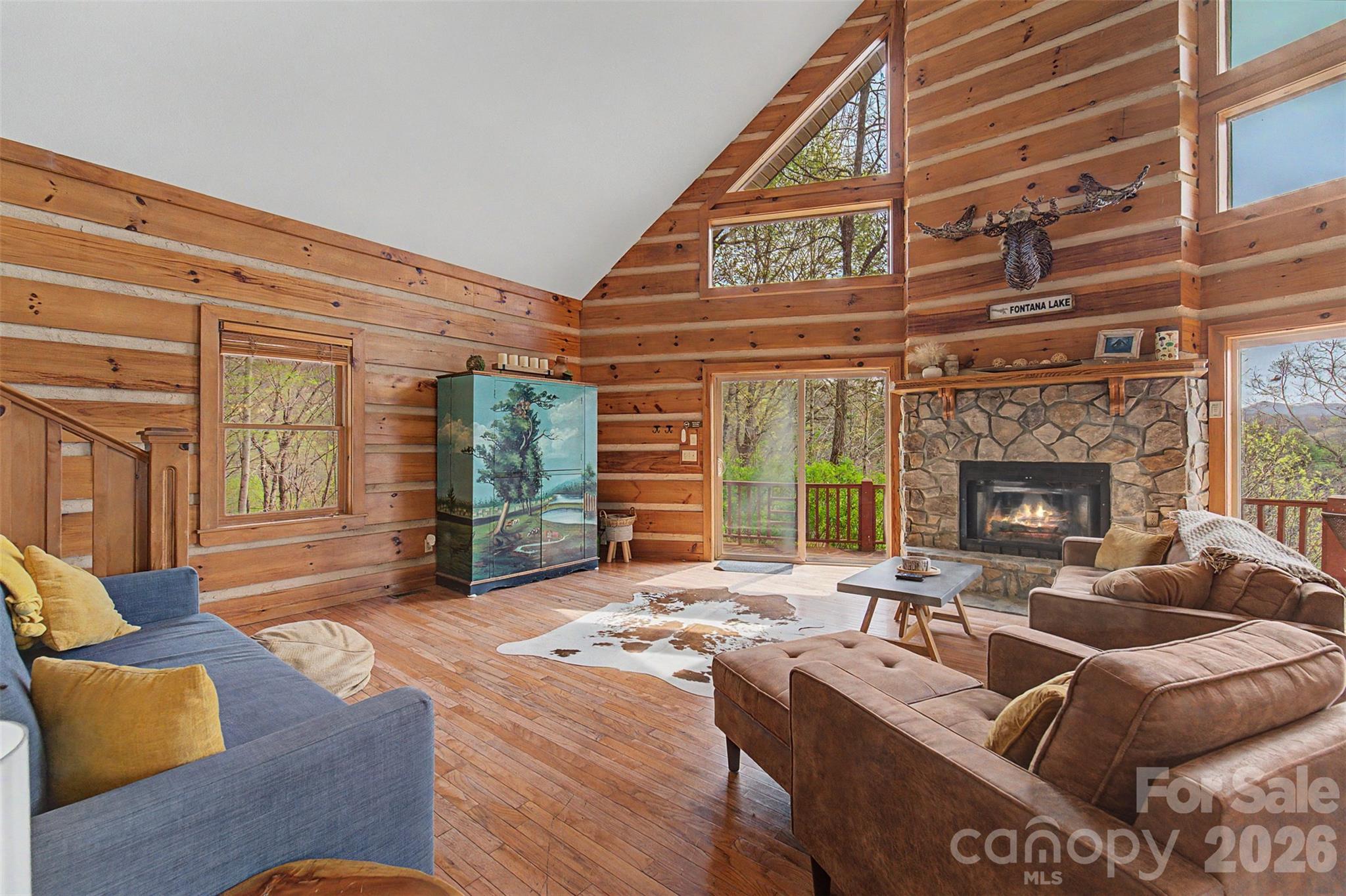 183 Ridge Place Bryson City, NC 28713 - Photo 8 of 44 a living room with furniture a fireplace and large windows