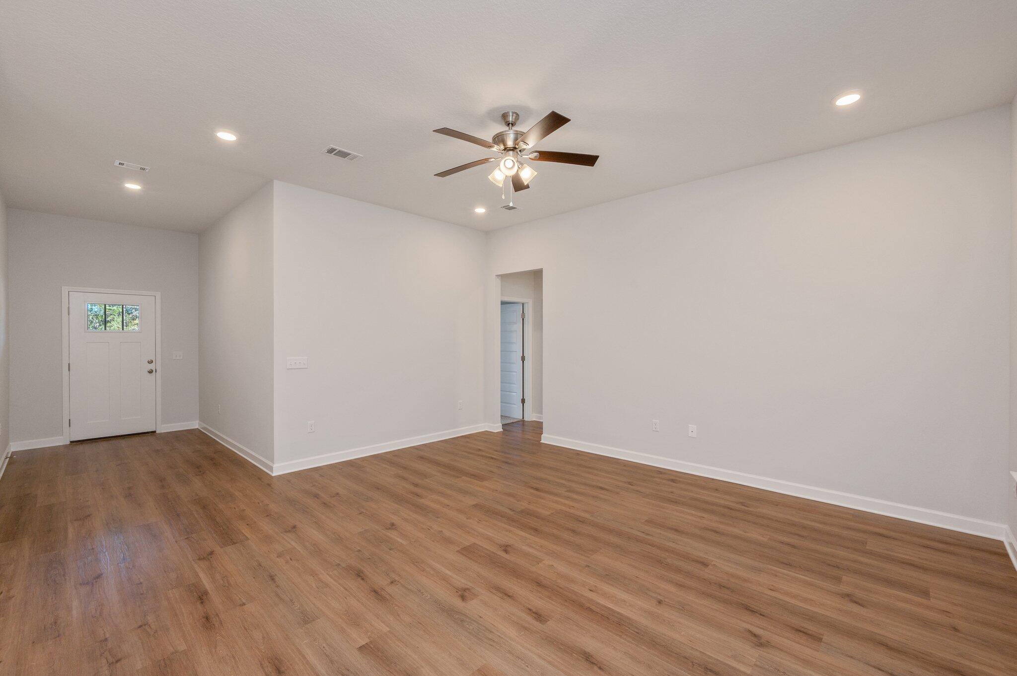 2614 Sorrel Ridge Road Crestview, FL 32536 - Photo 8 of 35 a view of an empty room with wooden floor and a ceiling fan