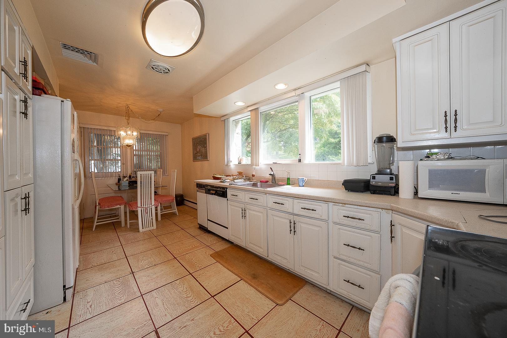 323 Hidden River Road Penn Valley, PA 19072 - Photo 8 of 29 a large white kitchen with cabinets