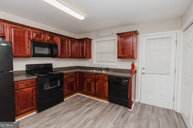 a kitchen with stainless steel appliances granite countertop a refrigerator stove and a sink