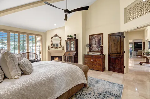 a bedroom with a large bed and wooden floor