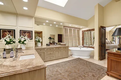 a large bathroom with a granite countertop tub a sink and a large mirror
