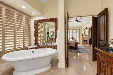 a spacious bathroom with a bathtub and a large mirror