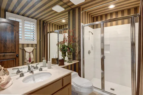 a bathroom with a sink a toilet and shower