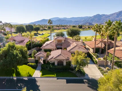 a view of multiple houses with a yard and a garden