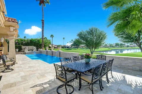 a view of backyard with swimming pool and outdoor seating