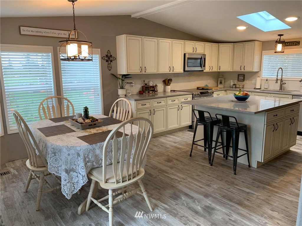 1769 Pangborn Road Lynden, WA 98264 - Photo 2 of 37 a kitchen with granite countertop a dining table chairs and white cabinets