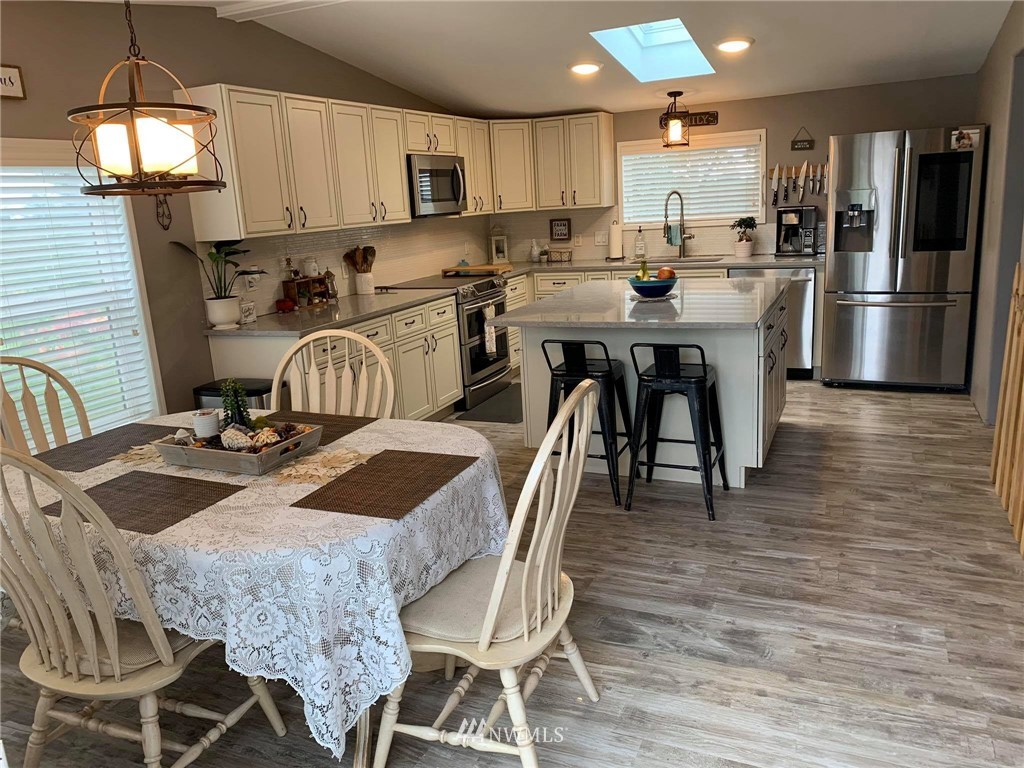 1769 Pangborn Road Lynden, WA 98264 - Photo 5 of 37 a kitchen with stainless steel appliances granite countertop a dining table chairs stove refrigerator and cabinets
