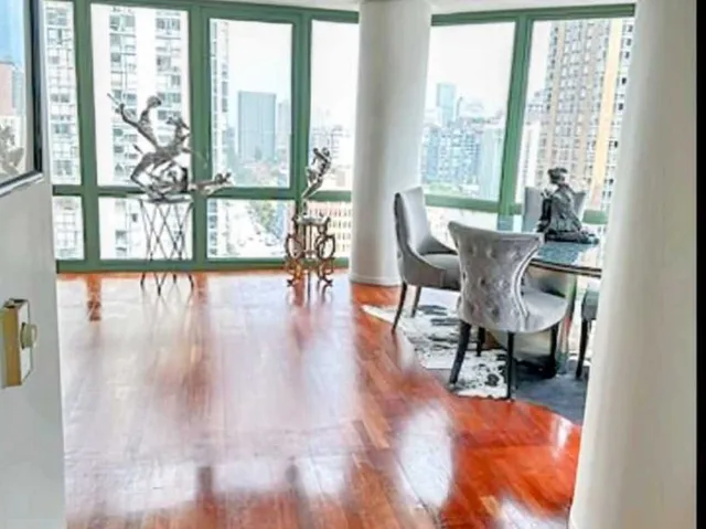 a dining room with furniture water view and a floor to ceiling window