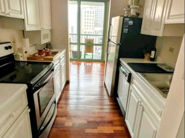 a kitchen with granite countertop a stove sink and cabinets