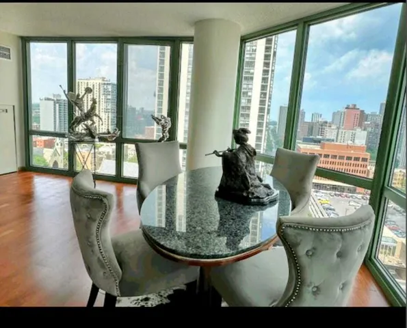 a view of a dining room with furniture large windows and wooden floor