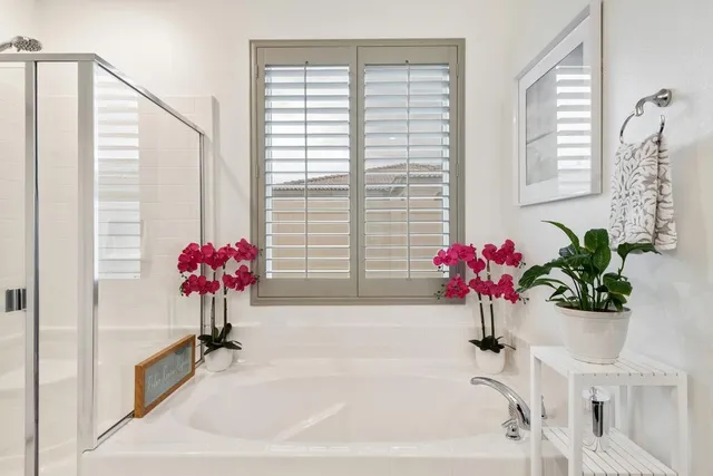 a white bath tub sitting in a bathroom next to a window