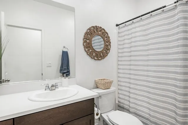 a bathroom with a toilet a sink and a mirror