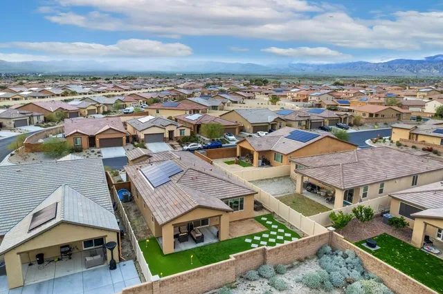 a front view of a house with a yard and potted plants