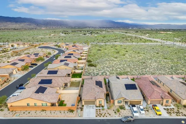 a front view of a house with a yard and a car park