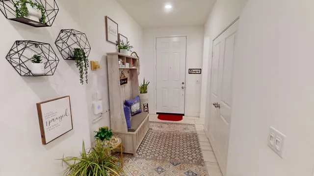 a hallway with painting on the wall and a potted plant