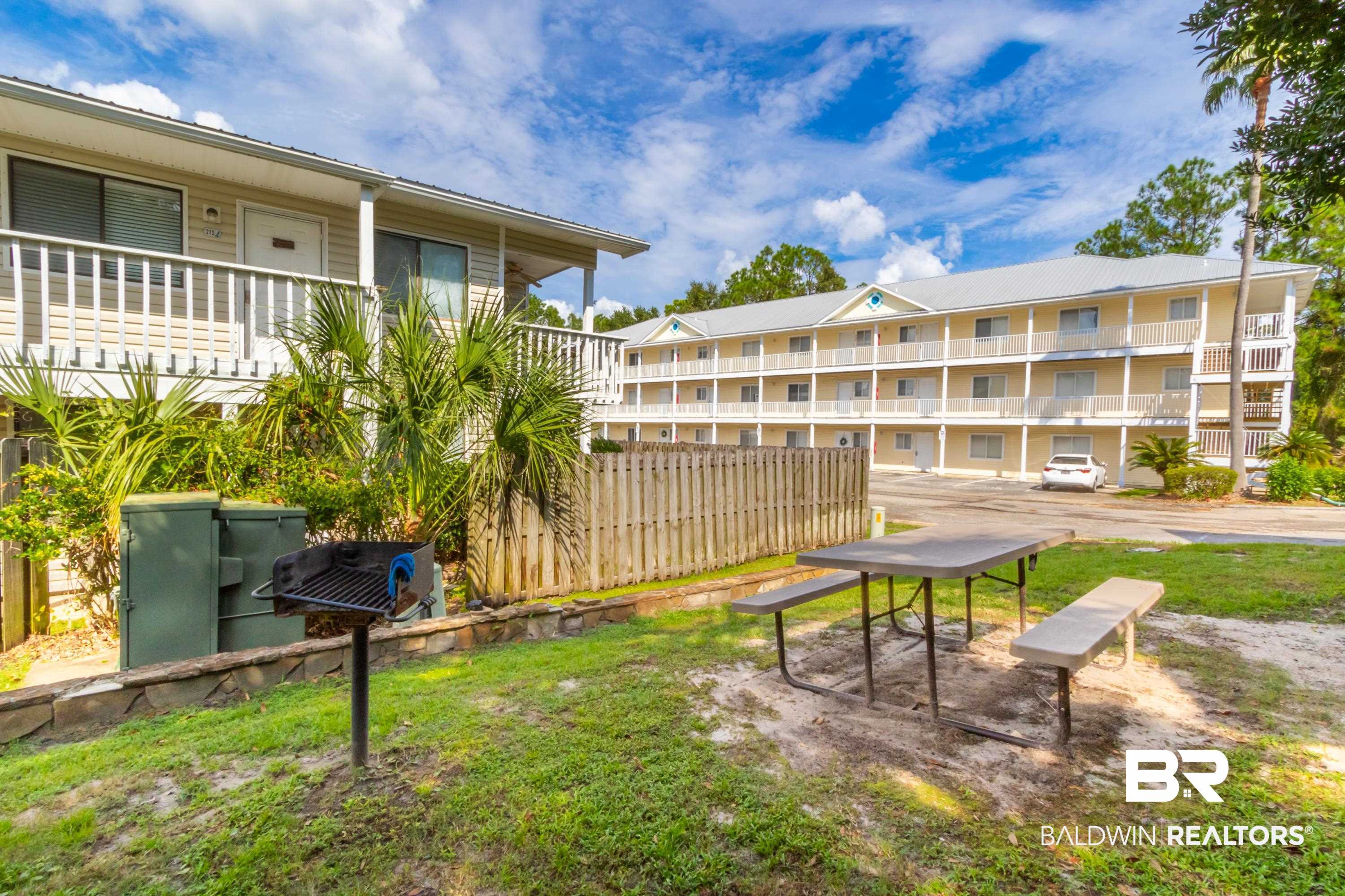 25957 Canal Road, Unit 208 Orange Beach, AL 36561 - Photo 24 of 28 Outdoor picnic table and bench set on a grass area with a barbecue grill