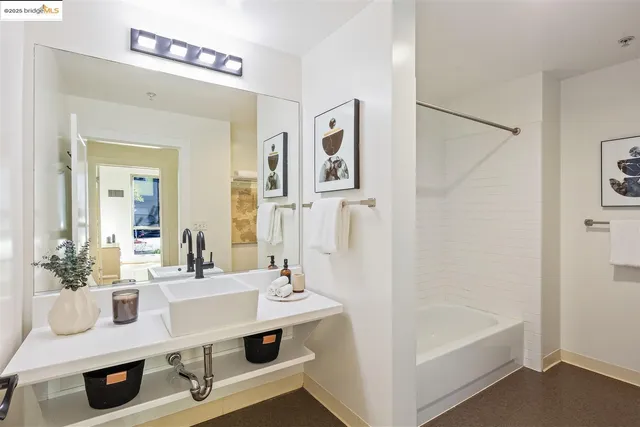 a bathroom with a sink a tub and a mirror
