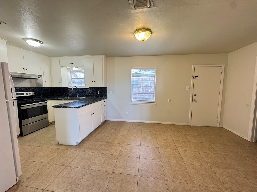 a kitchen with a sink a counter top space stainless steel appliances and cabinets