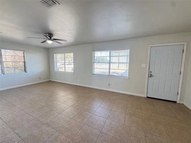 an empty room with fan and windows