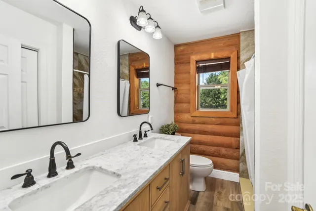 a bathroom with a granite countertop toilet a sink and a mirror