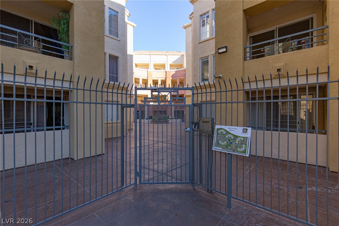 210 East Flamingo Road, Unit 117 Las Vegas, NV 89169 - Photo 3 of 24 Gated entry pathways lead into a central courtyard framed by multi-level residential structures.