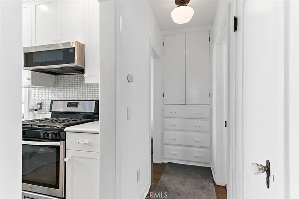 a kitchen with white cabinets and stainless steel appliances