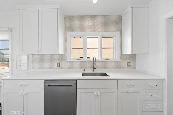 a kitchen with white cabinets and a sink