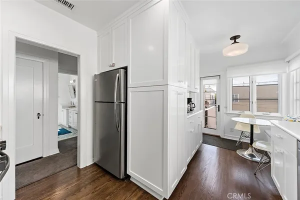 a kitchen with a refrigerator a sink and dishwasher with wooden floor