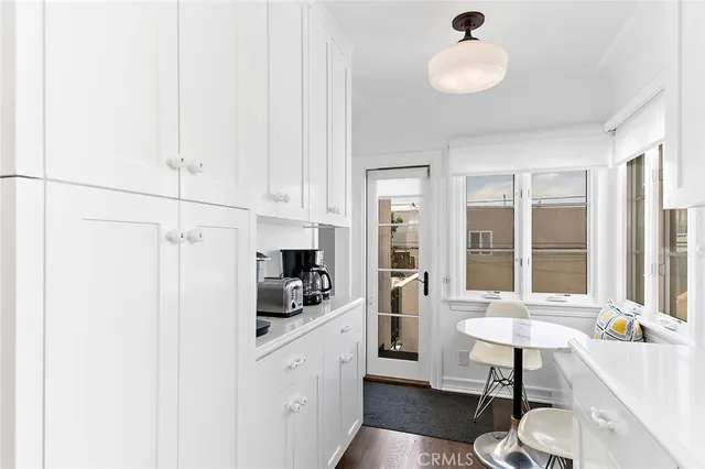 a kitchen with a refrigerator and white cabinets