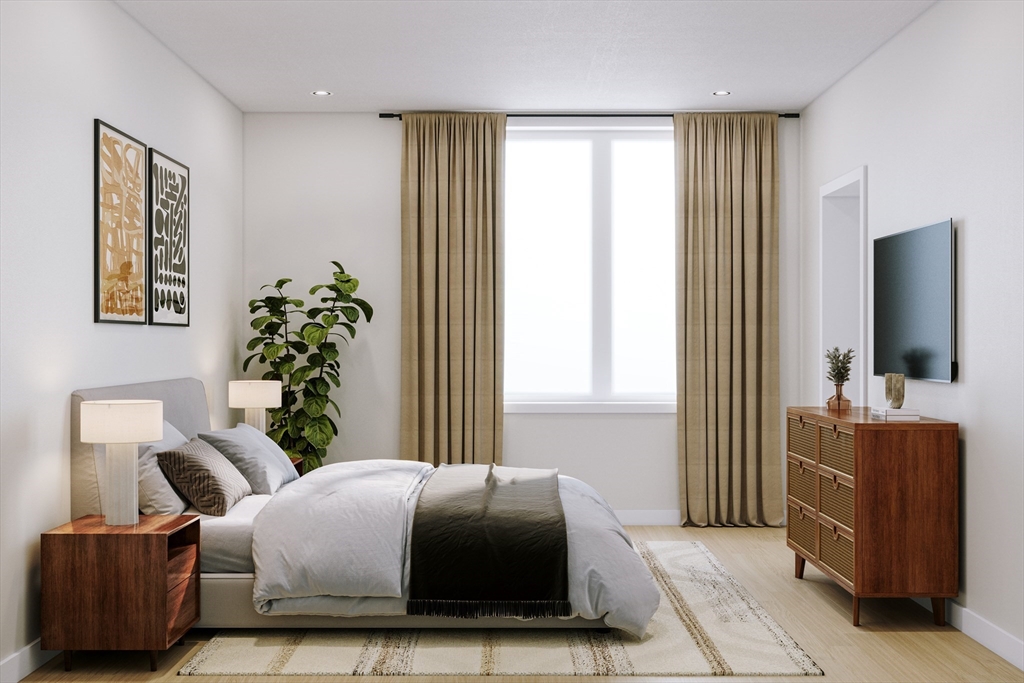 25 Adams Circle, Unit A Devens, MA 01434 - Photo 10 of 22 a bedroom with a balcony a bed and a couch