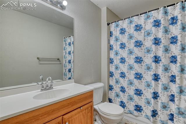 7863 Buschborn Road Peyton, CO 80831 - Photo 25 of 50 Bathroom featuring a textured ceiling, vanity, and toilet