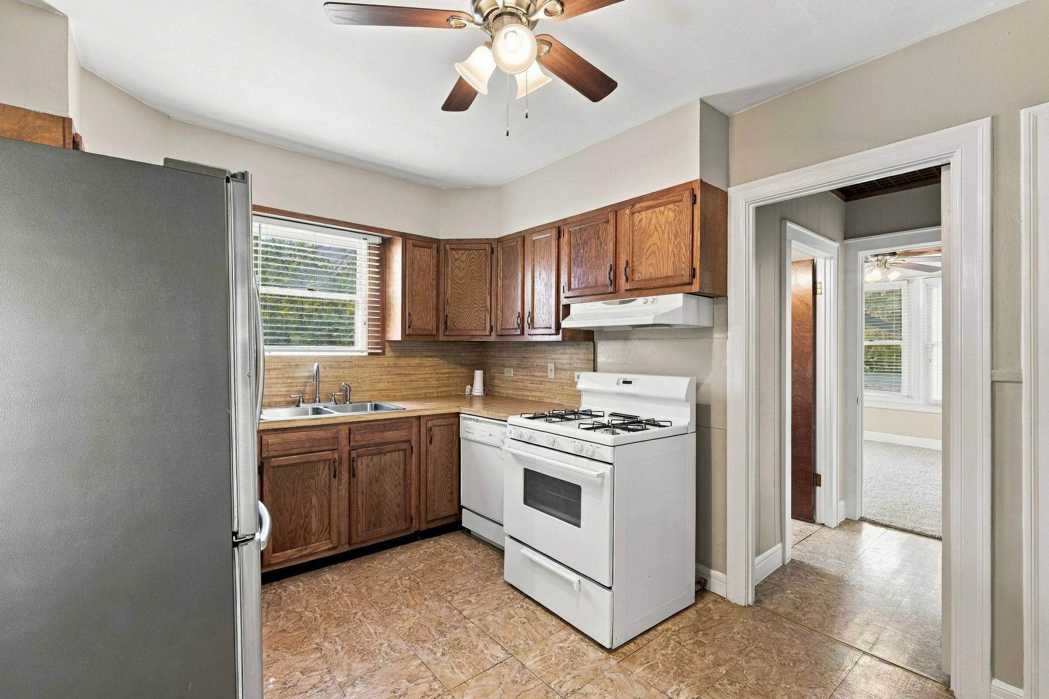 2303 Kinney Road Austin, TX 78704 - Photo 5 of 17 Rich wood cabinetry and tile-look flooring define this classic culinary space with vintage appeal.