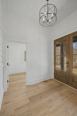 a view of an empty room with a fireplace and chandelier