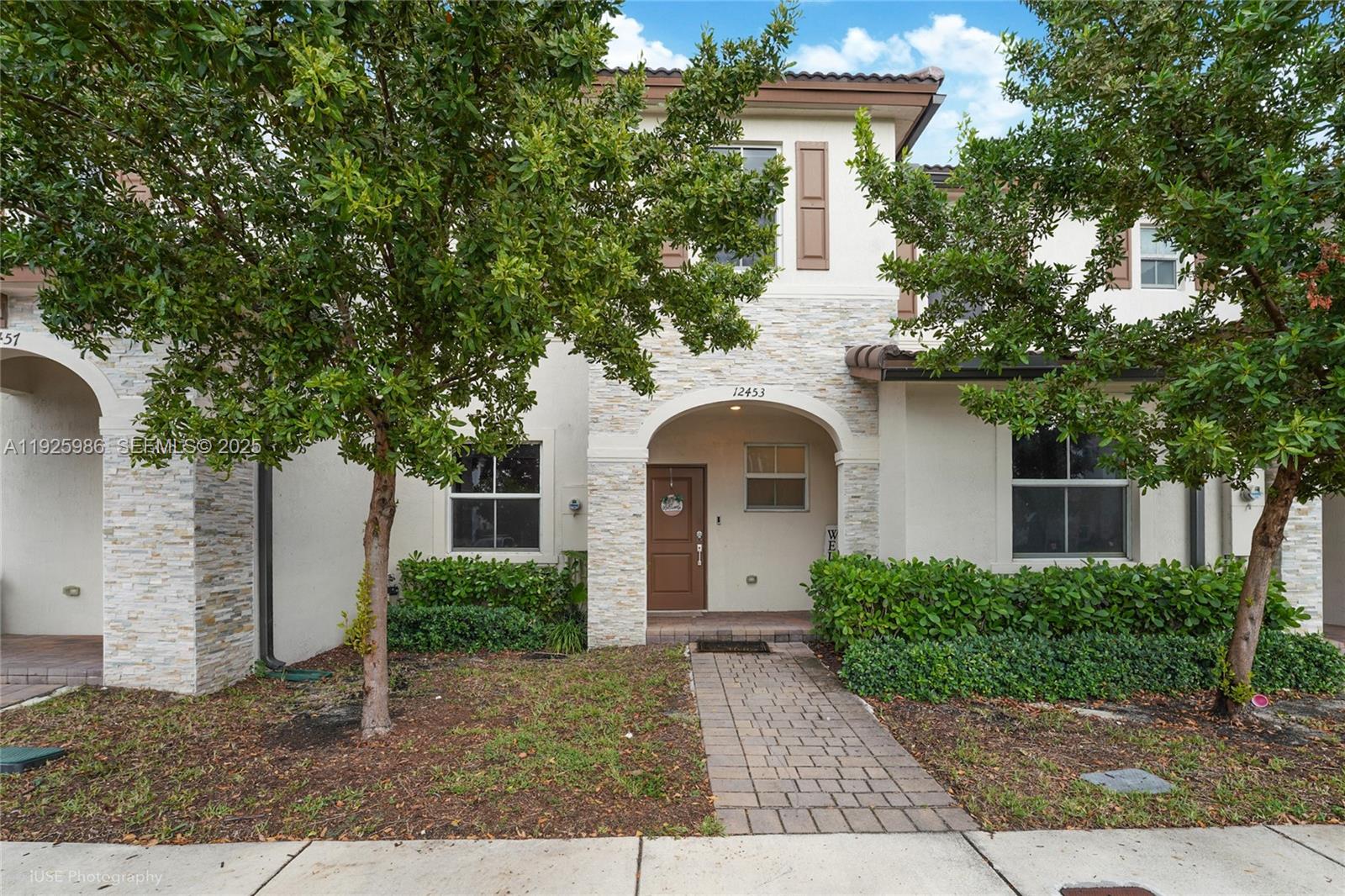12453 Northwest 23rd Court Miami, FL 33167 - Photo 1 of 15 a front view of a house with a yard and potted plants