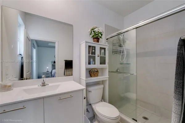 a bathroom with a sink a toilet and shower