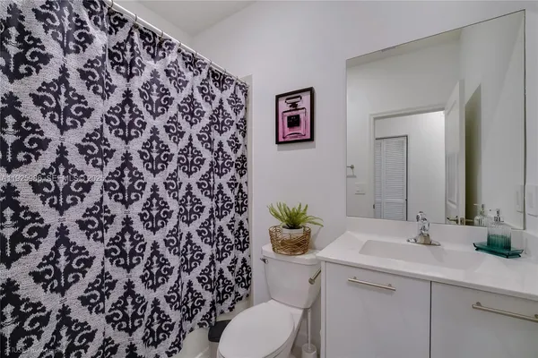 a bathroom with a granite countertop sink and a toilet