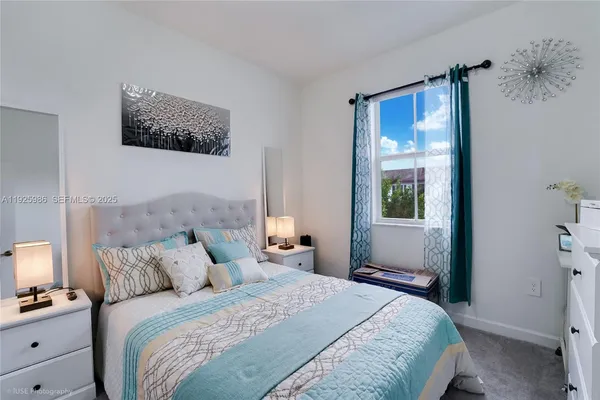 a bedroom with bed a lamp and a window