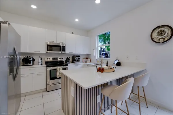 a kitchen with a sink a stove a microwave and cabinets